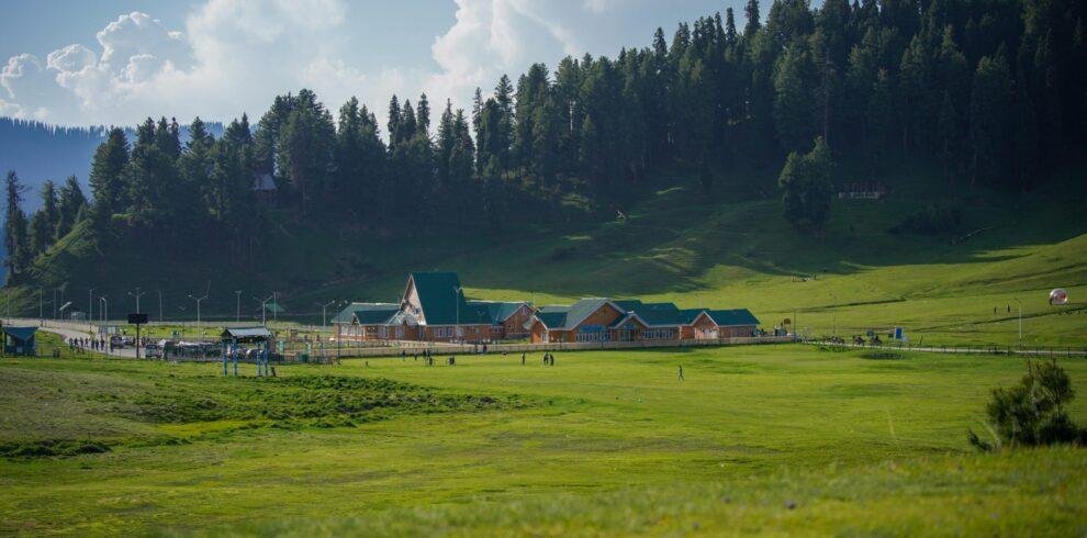 Panoramic hilltop view of Baisaran Valley’s lush green meadow and snow‑capped Pir Panjal mountains near Pahalgam, Kashmir, India