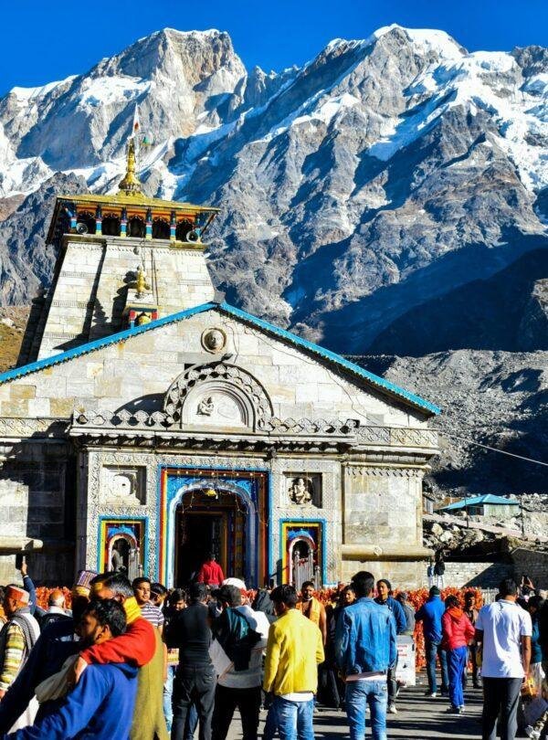 Front view of Kedarnath Jyotirlinga Temple surrounded by snow‑capped Himalayas